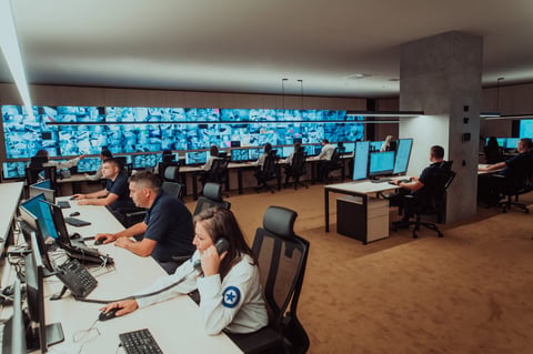 Security monitoring center operators watching multiple screens